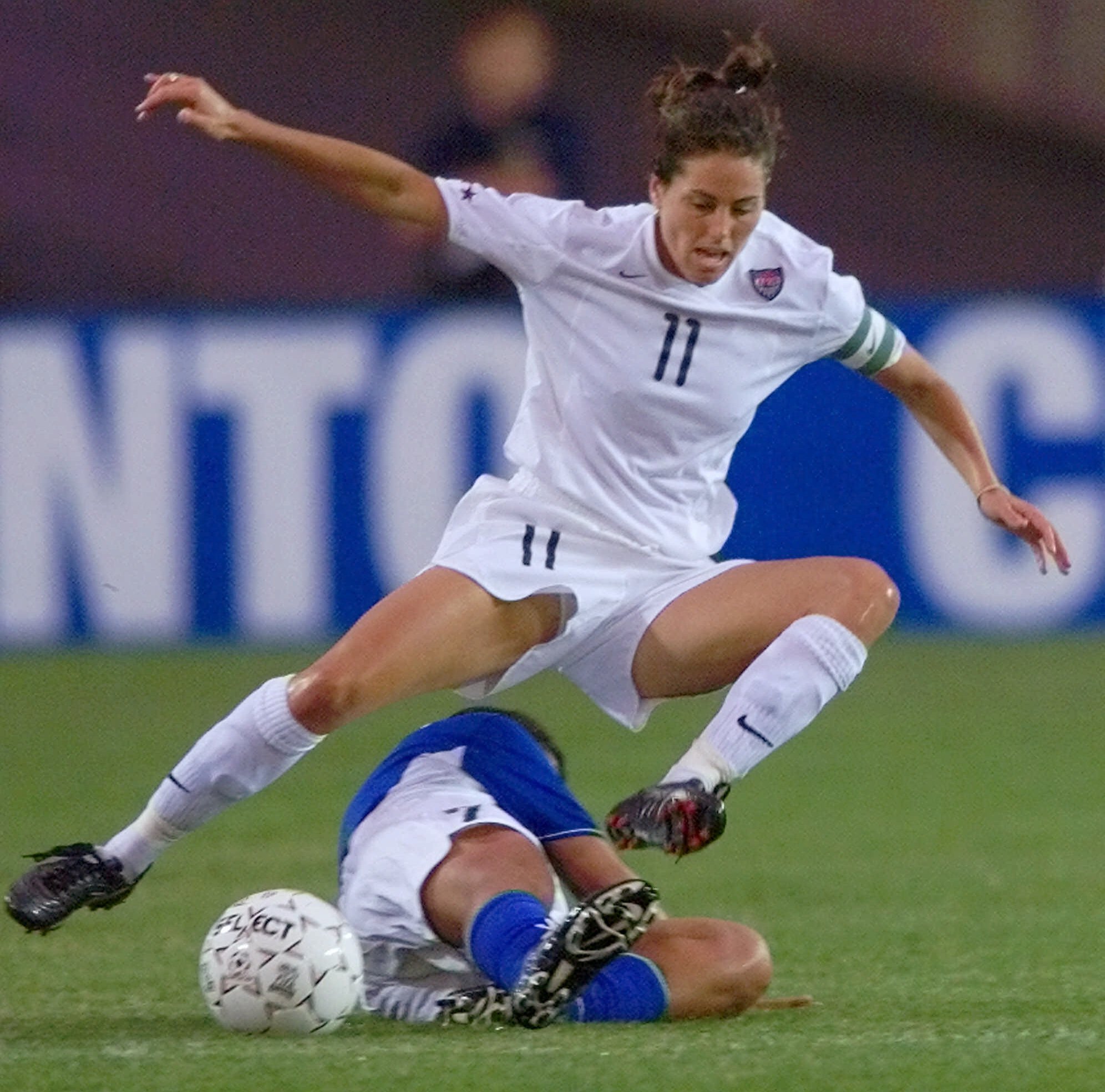U.S. midfielder Julie Foudy leaps over Brazil's Maria De Souza Diaz to control the ball during a 2000 Women's Gold Cup match in Foxboro, Massachusetts.